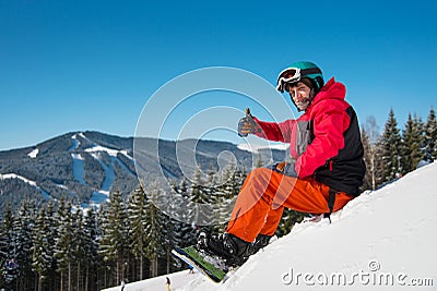 Snowboarder resting on top of the mountain Stock Photo
