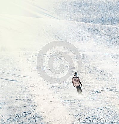 Snowboarder riding down a steep slope in bright sunlight Editorial Stock Photo