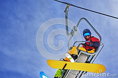 Snowboarder sitting on chairlift and smiling, close-up Stock Photo