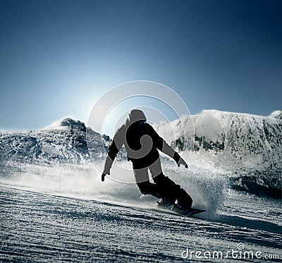 Snowboarder slides down the snowy hill Stock Photo