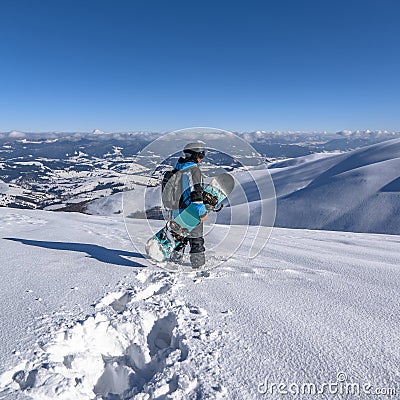 Snowboarder with snowboard in hand on mountain top. Winter freeride snowboarding Stock Photo