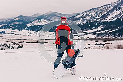 Snowboarder standing in front of the mauntains Stock Photo
