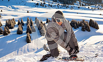 Snowboarder stands mountain top, buttoning fastening for a snowboard Stock Photo