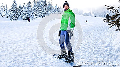 Snowboarder stands on the snowboard in the winter on a ski run Stock Photo