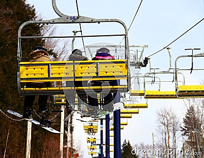 Snowboarders & Skier Family on Chairlift Stock Photo