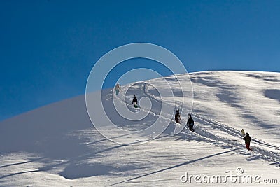 Snowboarders walking up the mountain Stock Photo