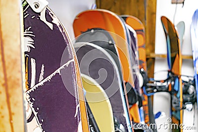 Snowboards, ski hanged on customized wooden wall mount at warehouse for seasonal storage,ski resort Stock Photo