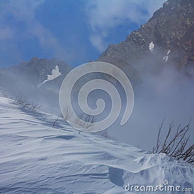 snowbound mountain valley in dense mist Stock Photo