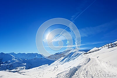 Snowcapped alpine path with anti avalanche barrier Stock Photo