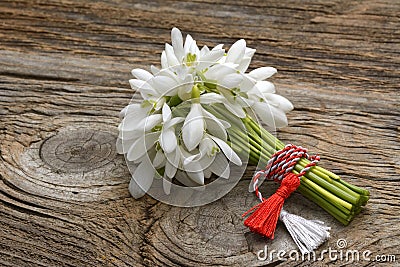 Snowdrops, 1st of March tradition white and red cord martisor isolated on wooden background Stock Photo