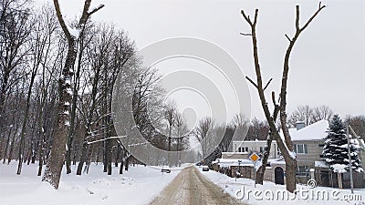 After the snowfall, everything is covered with snow. Snow lies on lawns, houses, tree branches and continues to fall. The paved ro Stock Photo