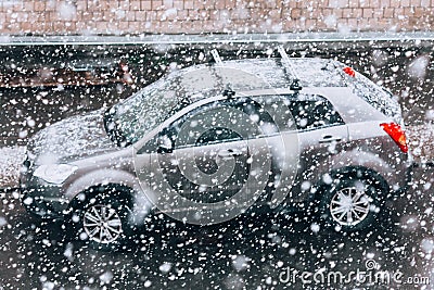 Snowfall on the road. Blurred heavy snowfall with snowflakes in the foreground and a car in the background. Blizzard. Concept on p Stock Photo