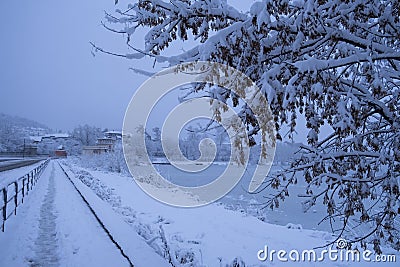 Snowfall and slippery road. Road safety in winter with snowfall. Winter cityscape. Small town street. Snow covered sidewalk. Urban Stock Photo