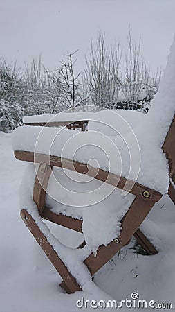 Snow on a wooden garden chair Stock Photo