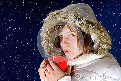 Snowing on young woman drinking something hot Stock Photo