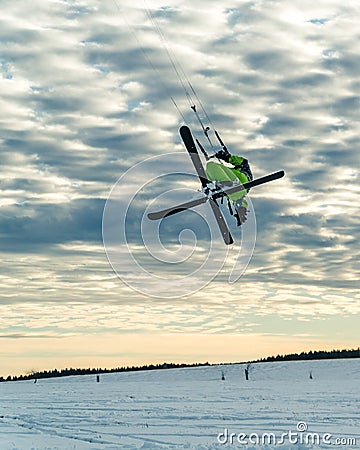 Snowkiter doing a freestyle trick while snowkiting with ski in winter conditions and beautiful sky Stock Photo