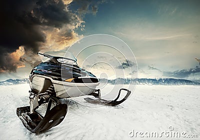 Snowmachine on the mountain lake frozen surface with thunderstorm clouds on the background Stock Photo