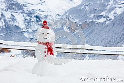 Snowman in Alps mountains. Snow man building fun in winter mountain landscape. Family outdoor activity in snowy cold season. Stock Photo