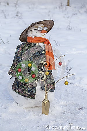 Snowman in Asian clothes, sunglasses and straw hat in the yard. Closeup Stock Photo