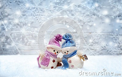 Snowman couple set against each other with snowflakes on the background Stock Photo