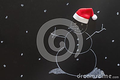 Snowman drawn with chalk on blackboard with Santa Claus hat, creative concept christmas background Stock Photo