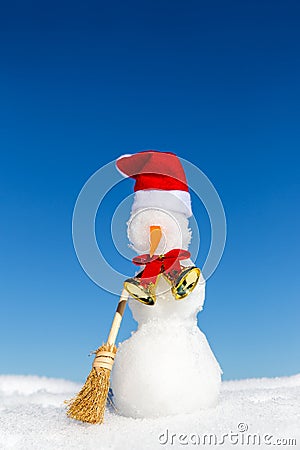 Snowman with a red cap and a broom in the snow Stock Photo