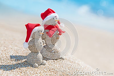 Snowmans couple at sea beach in christmas hat. New years holiday Stock Photo