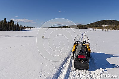 Snowmobile on a track on a frozen morass Stock Photo