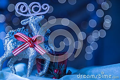 Snowy Blue Closeup Reindeer Ornament Christmas Bokeh Background. Stock Photo