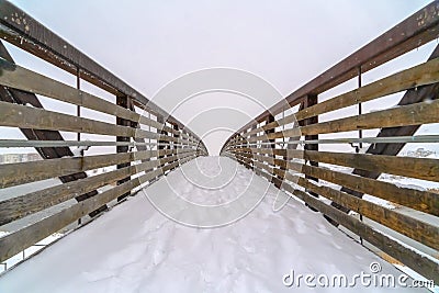 Snowy bridge with footsteps during winter in Utah Stock Photo