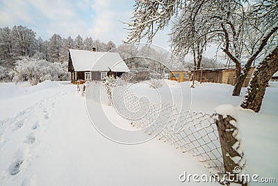 Snowy countryside of little wooden houses near forest Stock Photo