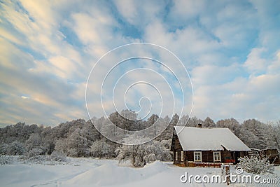 Snowy countryside of little wooden houses near forest Stock Photo