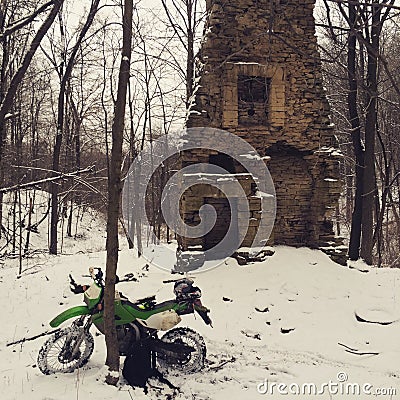 Snowy dual sport ride near building remains Stock Photo