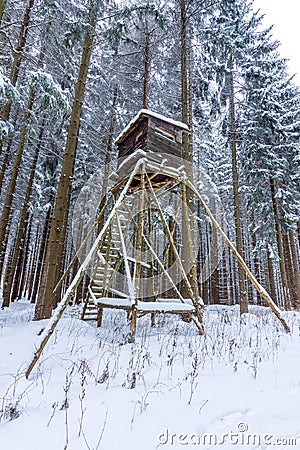 Snowy hunting high gamekeeper hidden in the middle of the forest. Stock Photo