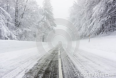 Snowy and icy road in foggy weather Stock Photo