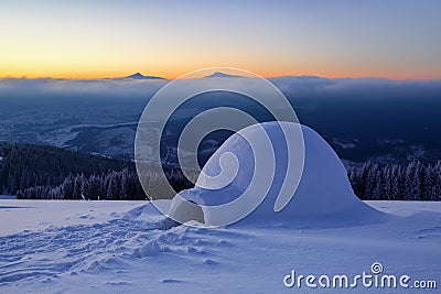 On the snowy lawn in the snowdrift there is an igloo. Stock Photo