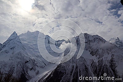 Snowy Mountains peaks in the clouds blue sky Caucasus Stock Photo