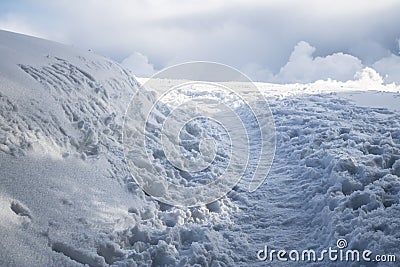 Snowy path with shoeprints, path in snow with clouds on the background, footsteps and path in snow Stock Photo