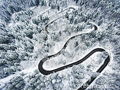 Snowy road in the forest. Extreme winding road high up in the mo Stock Photo