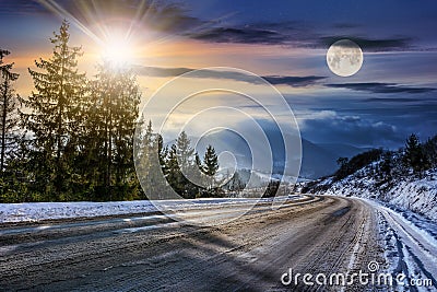 Snowy road through spruce forest in mountains Stock Photo