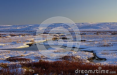 Snowy stream highlighted by evening sunlight, Langahlid, Iceland Stock Photo