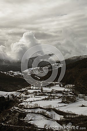 Snowy valley under a cloudy sky Stock Photo