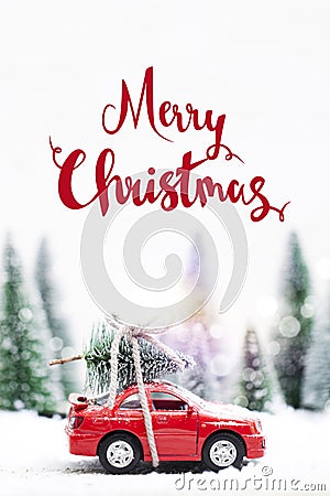 Snowy Winter Forest with miniature red car carrying a christmas Stock Photo