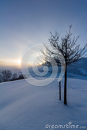 Snowy winter landscape in the alps, sunrise with halo phenomena Stock Photo