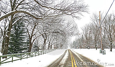 Snowy Winter Road Scene with Yellow Stripe Stock Photo