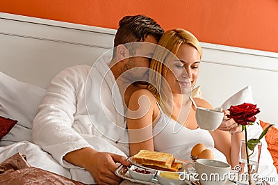 Snuggling couple romantic morning bed drinking coffee Stock Photo