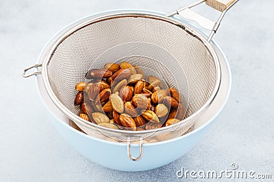 Soaked almonds in a strainer. Ingredients for nut milk Stock Photo