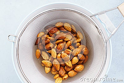Soaked almonds in a strainer. Ingredients for nut milk Stock Photo