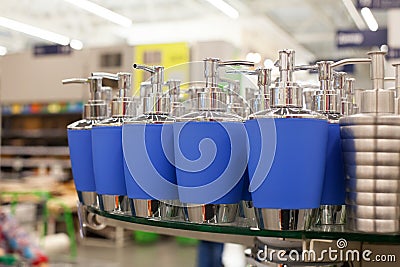 Soap dish dispenser for liquid soap, bathroom pastic and metal accessories in blue color on glass shelve in store close up, toilet Stock Photo