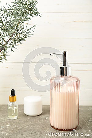 Soap dispenser with bath accessories on light background Stock Photo